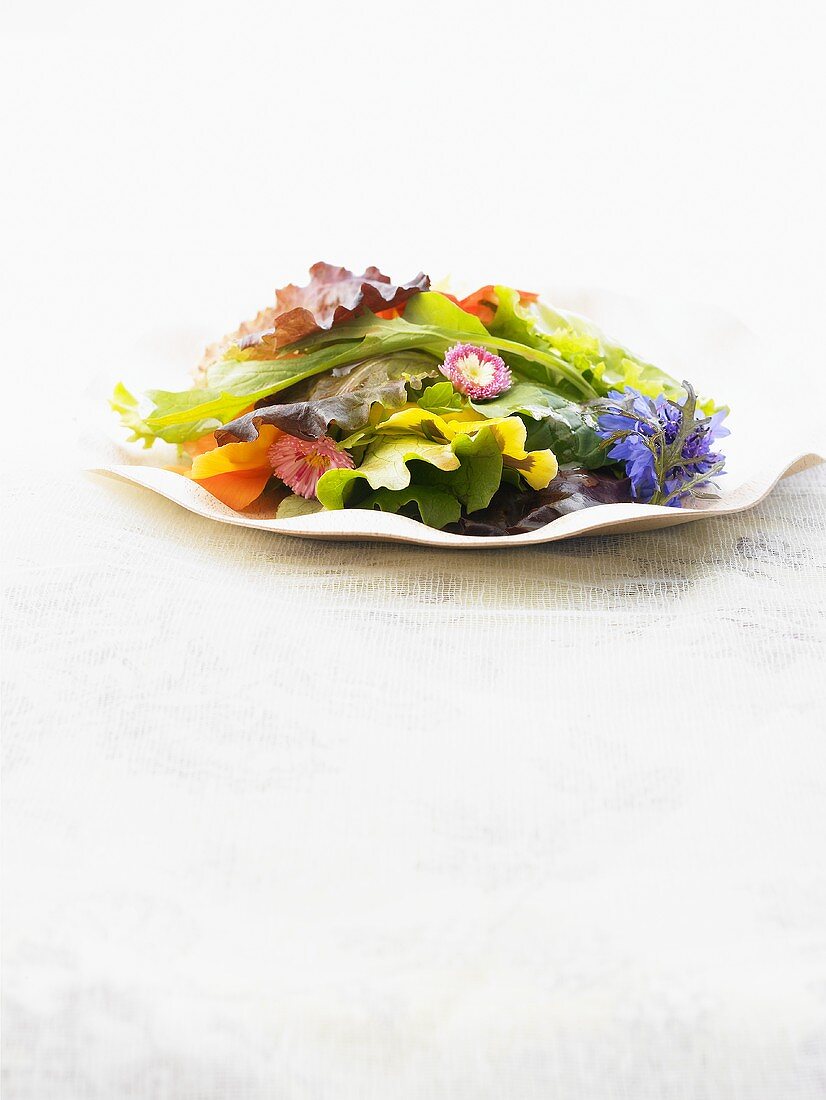 A plate of spring salad leaves and edible flowers