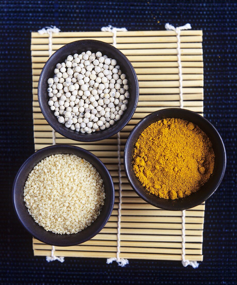 Currypulver, Sesamsamen und Mungobohnen in Schälchen