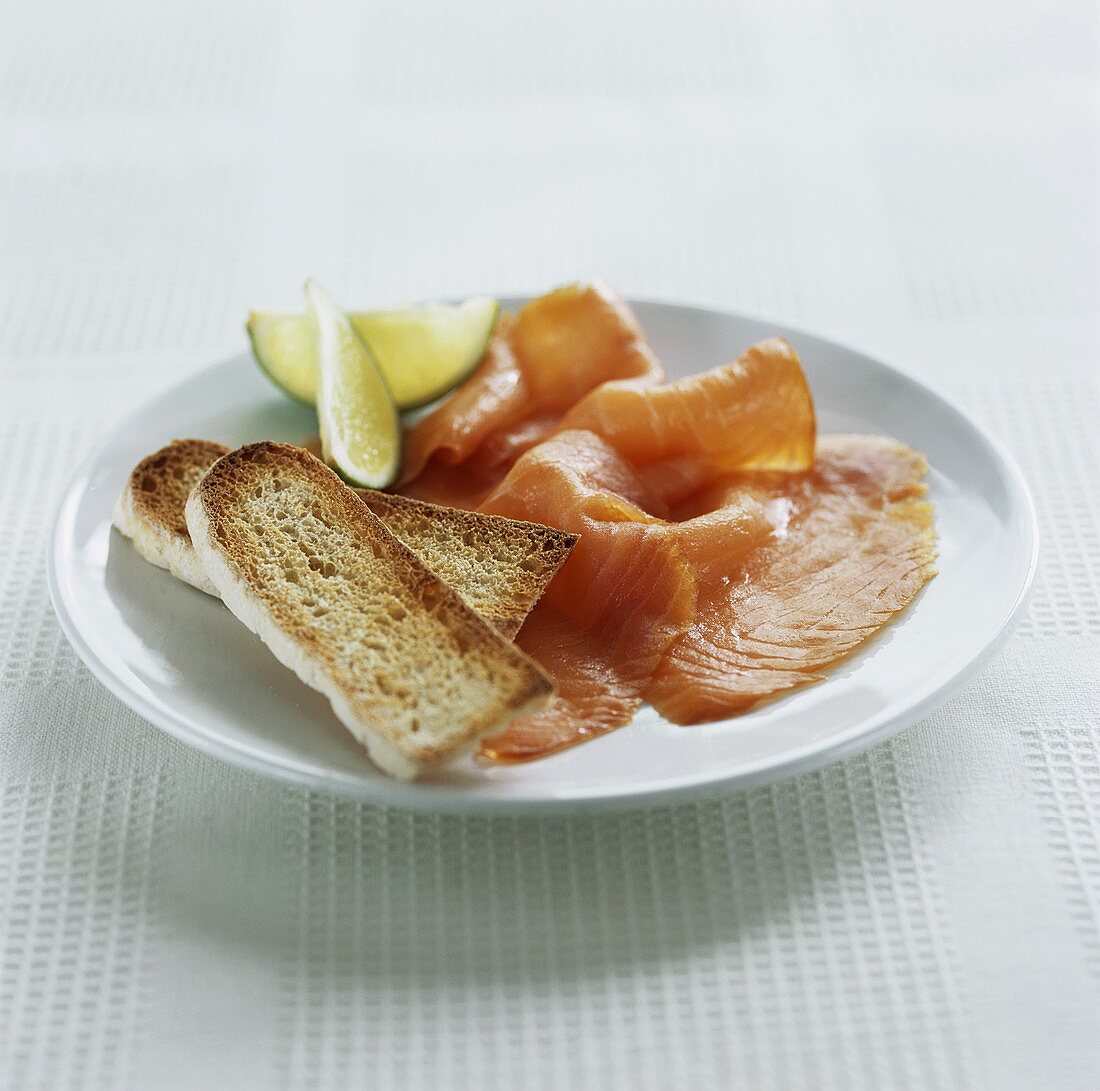 Smoked salmon with toasted white bread and lime wedges
