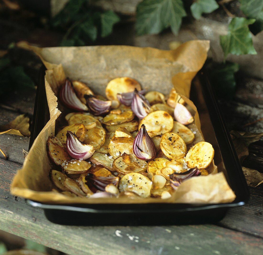 Gebackene Kartoffeln mit Knoblauch und Zwiebeln auf Backblech