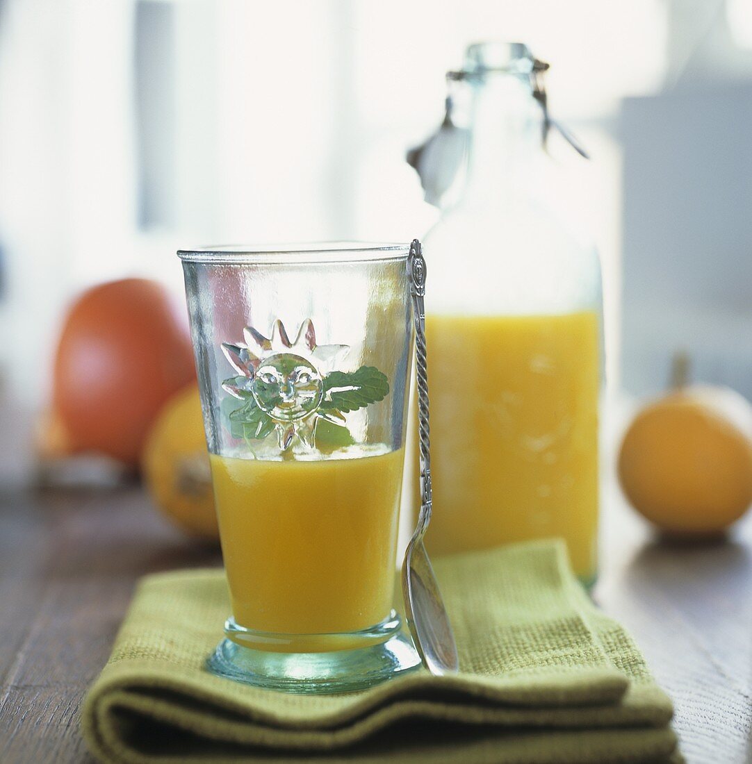 Pumpkin juice with vodka in bottle and glass