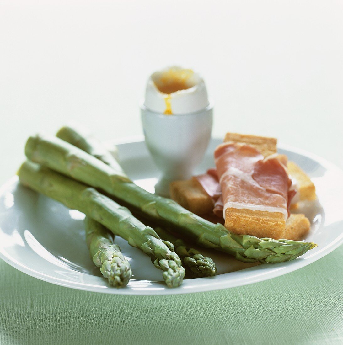 Grüner Spargel mit gekochtem Ei und Schinkentoast