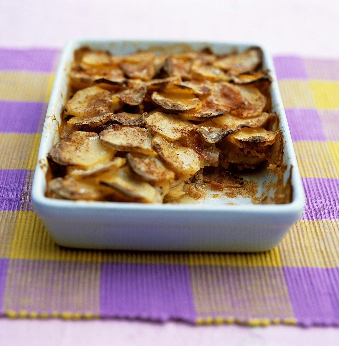 Potato gratin with ham on checked tablecloth