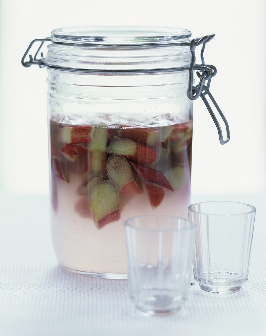 Bottled rhubarb in preserving jar, two glasses