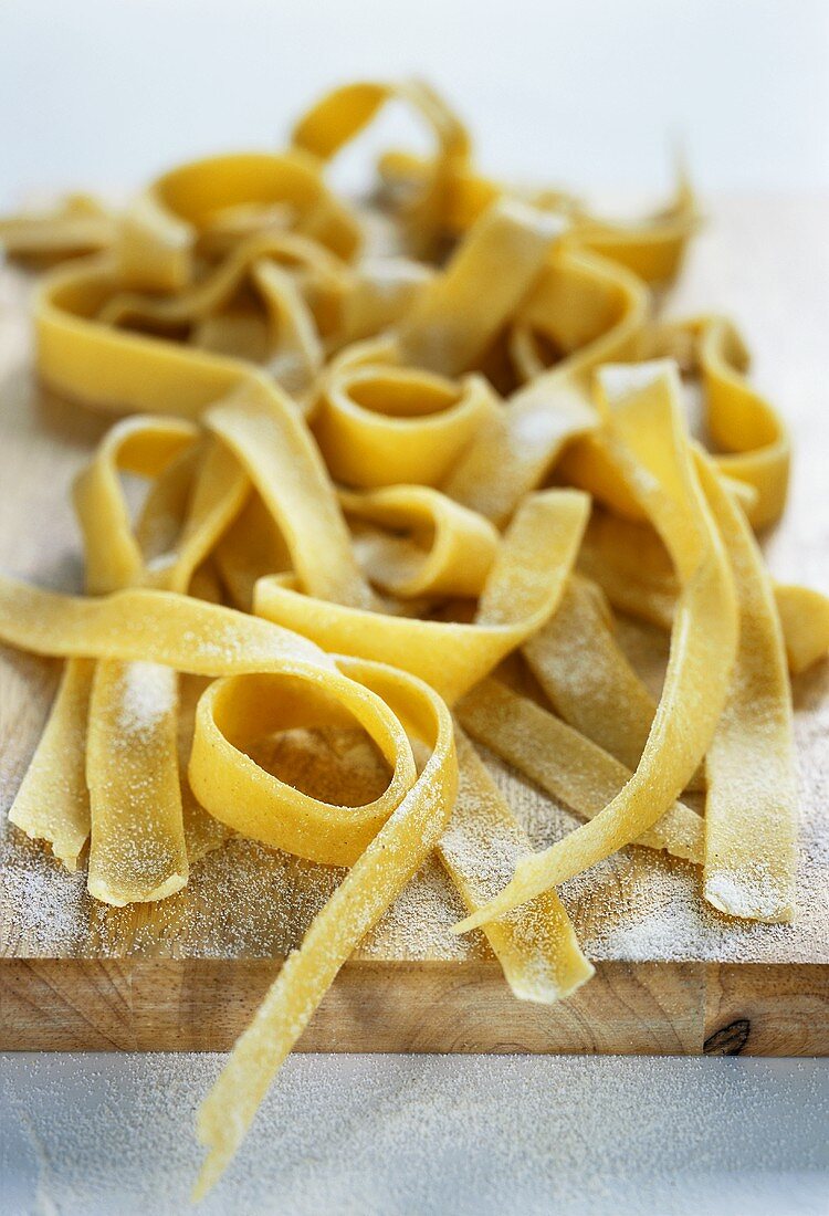 Frische Tagliatelle auf einem Holzbrett