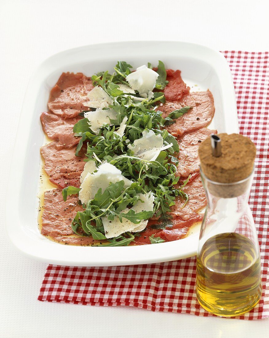 Beef carpaccio with rocket and Parmesan on a platter