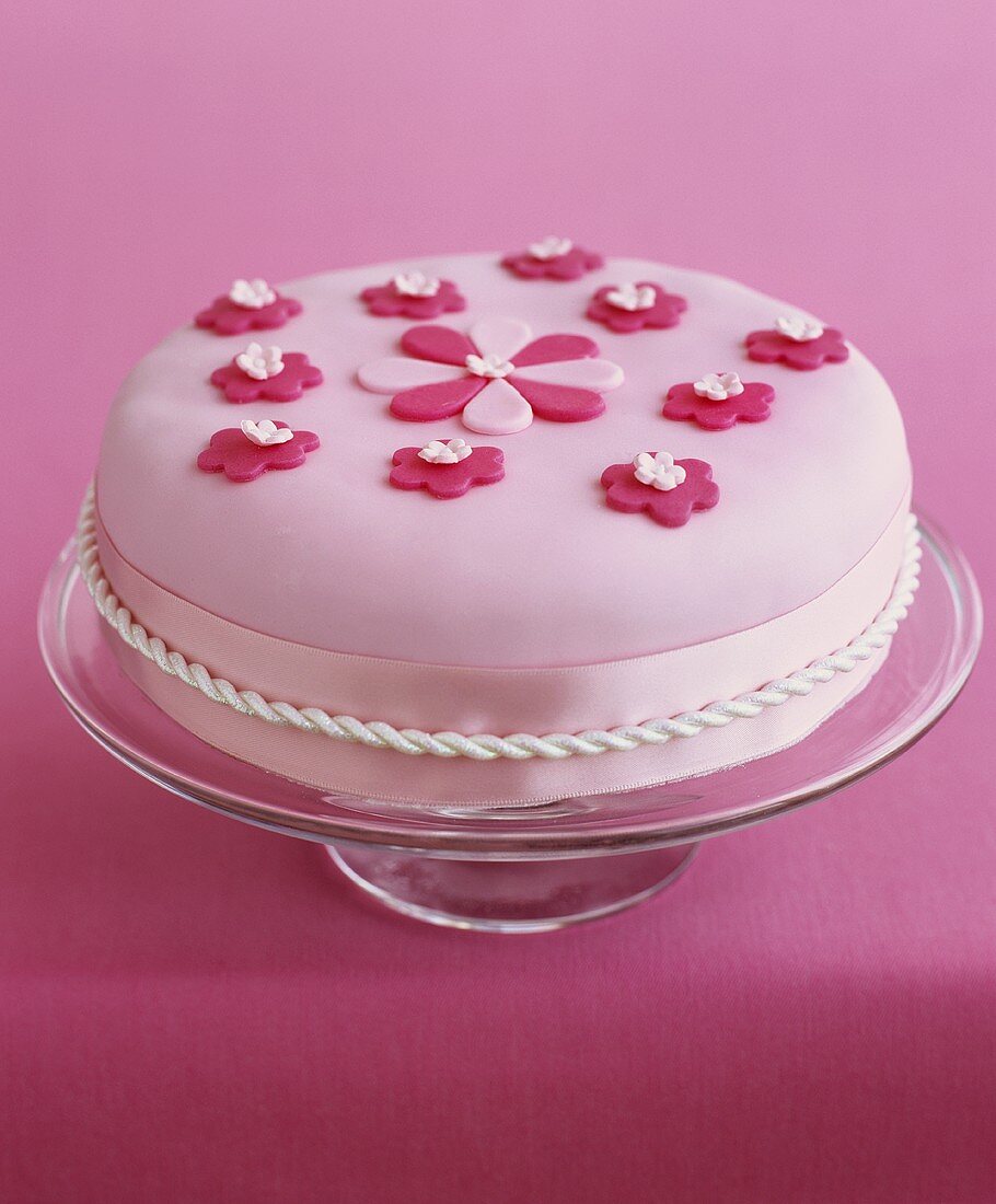 Fruit cake with pink fondant icing and sugar flowers