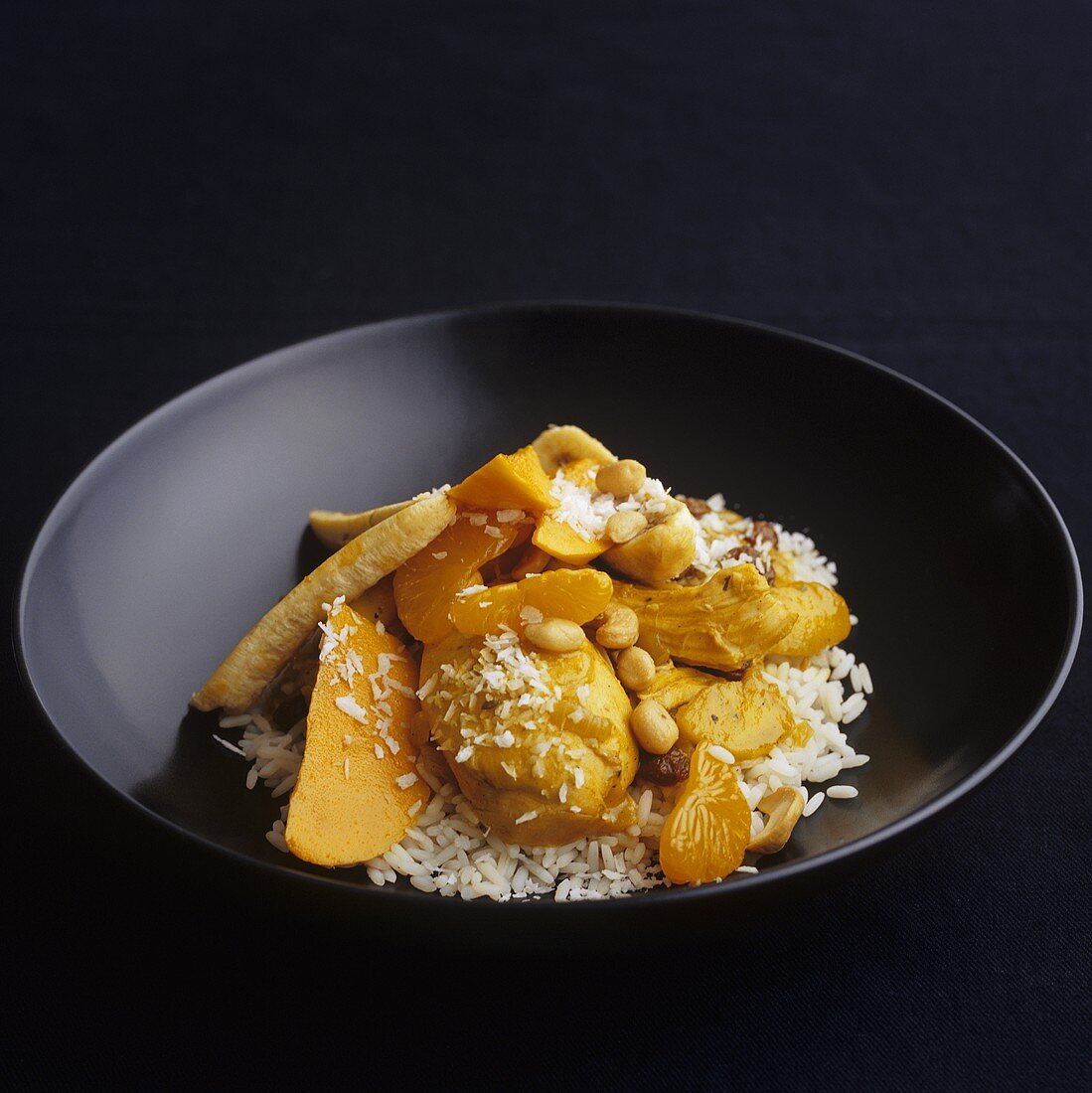 Chicken and mango curry with nuts and coconut on rice