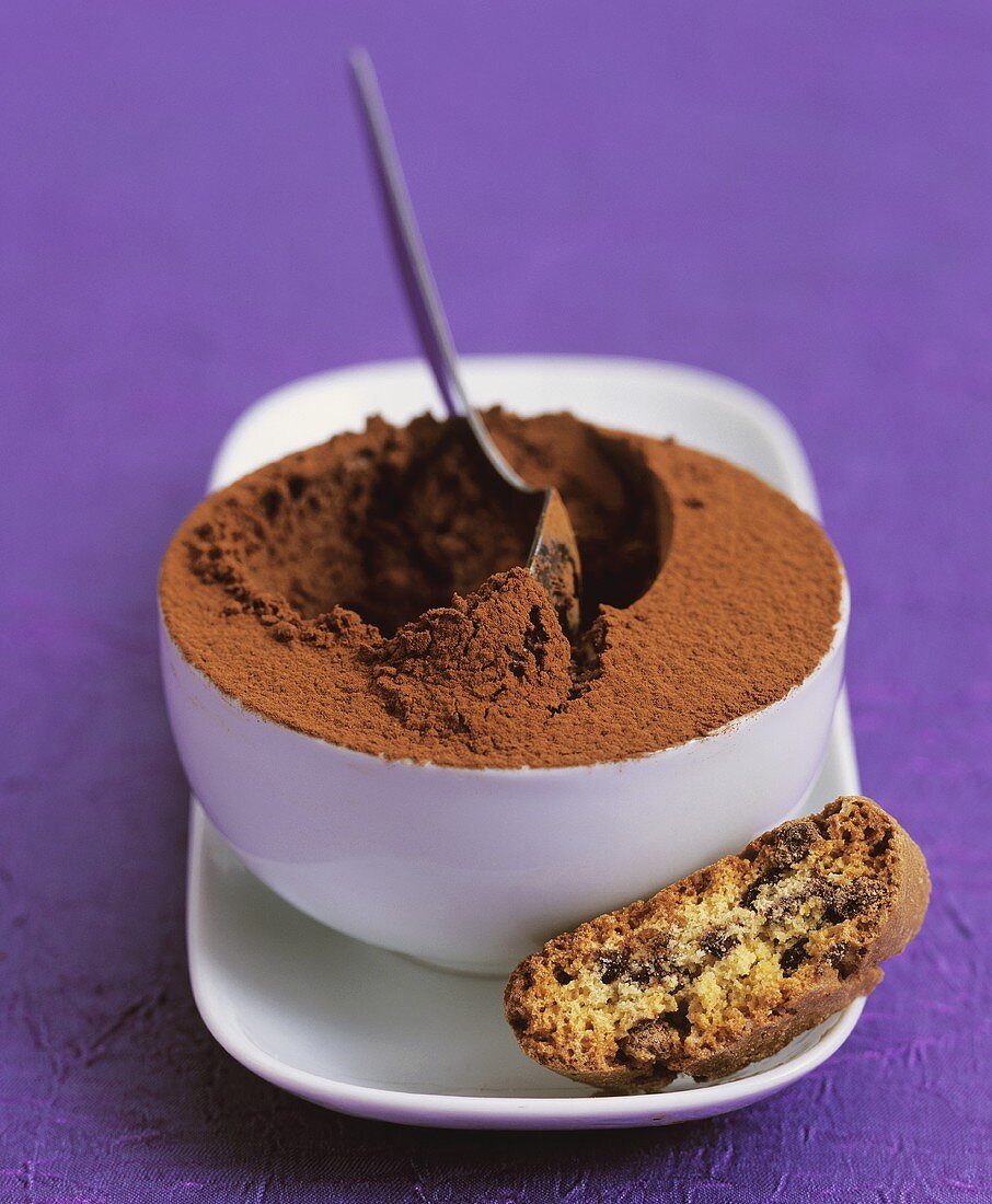 A bowl of mocha mousse with a biscuit
