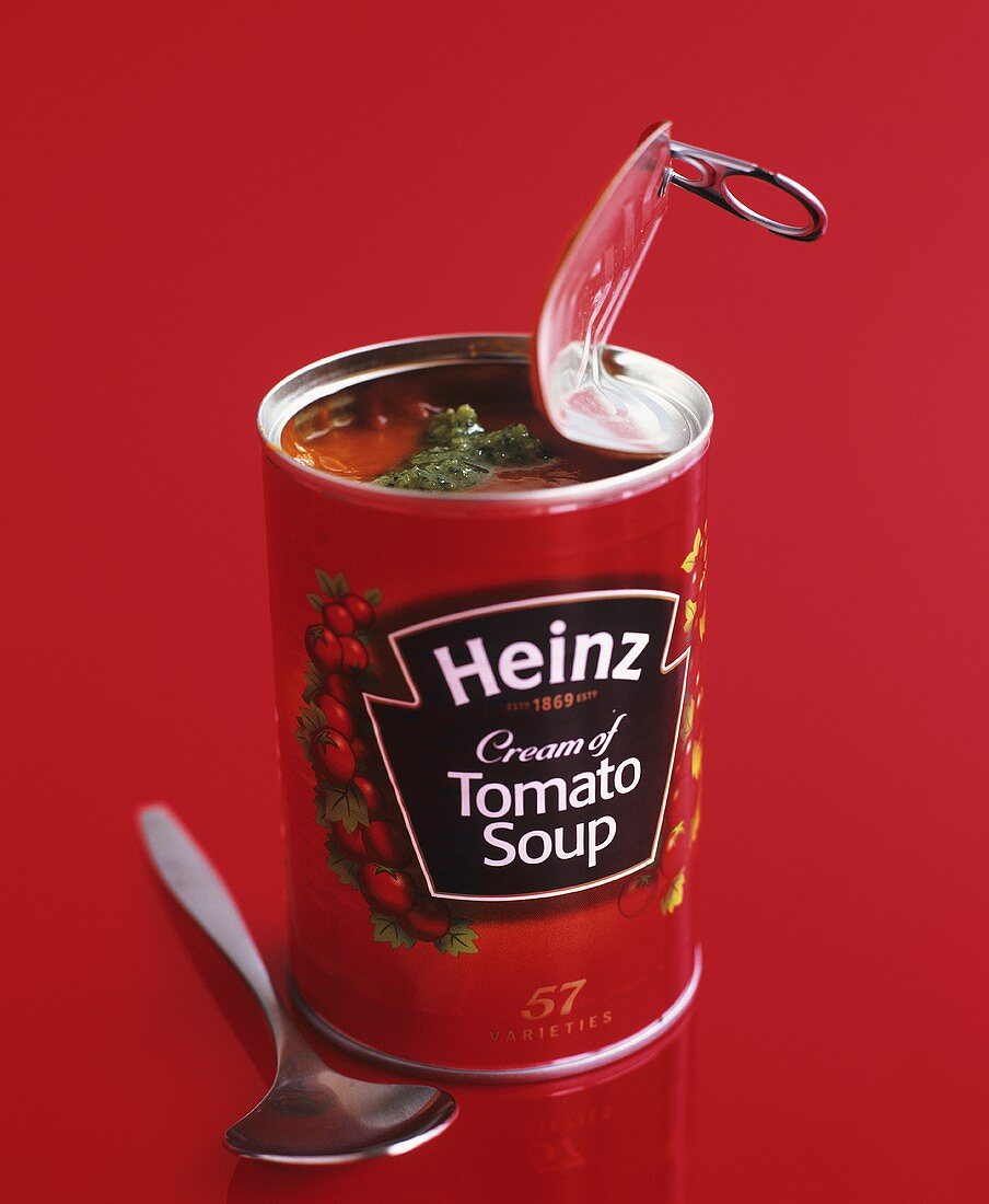 Eine geöffnete Dose 'Heinz Tomato Soup' mit Pesto und Löffel