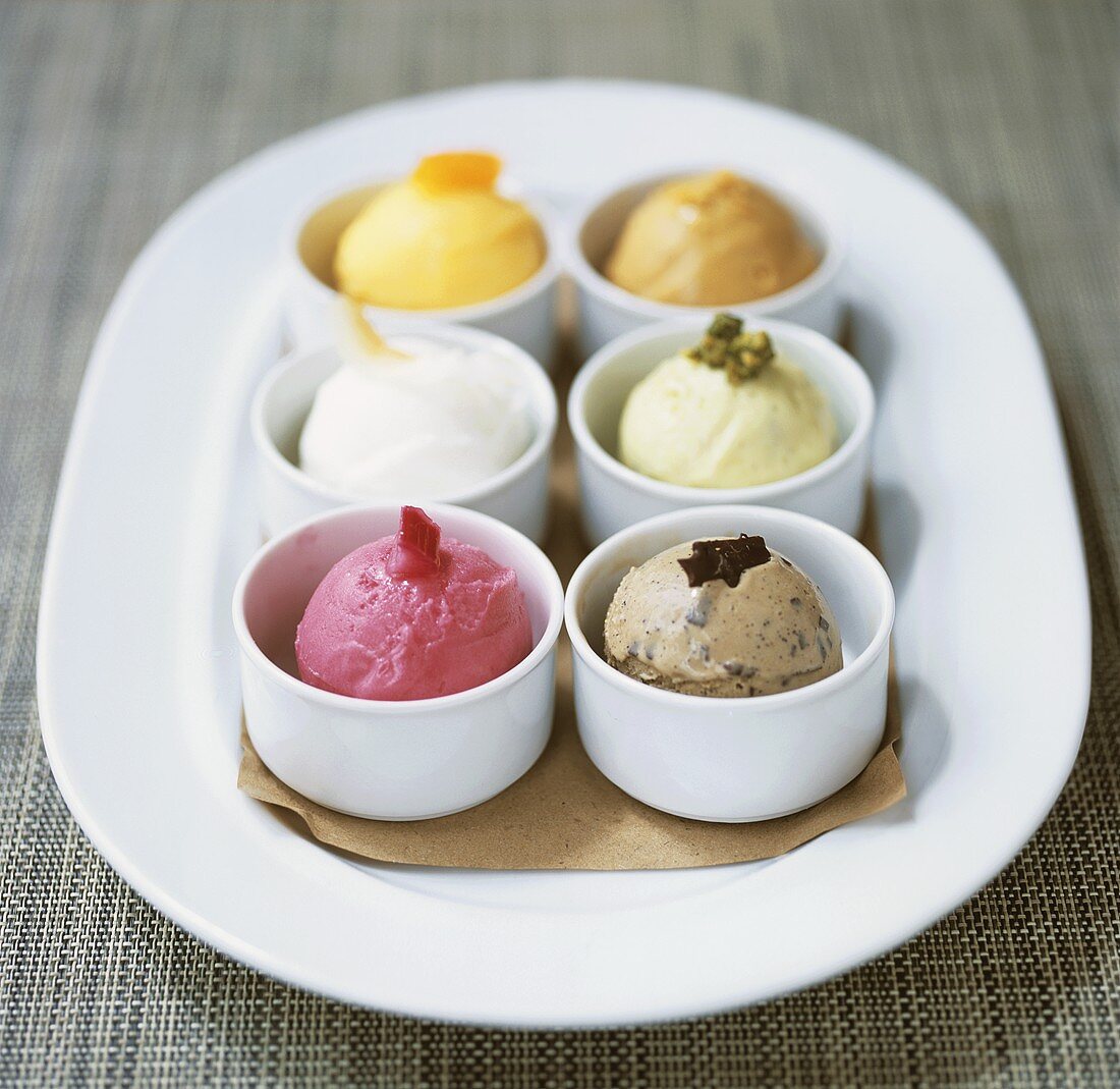 Scoops of six different ice creams in pots
