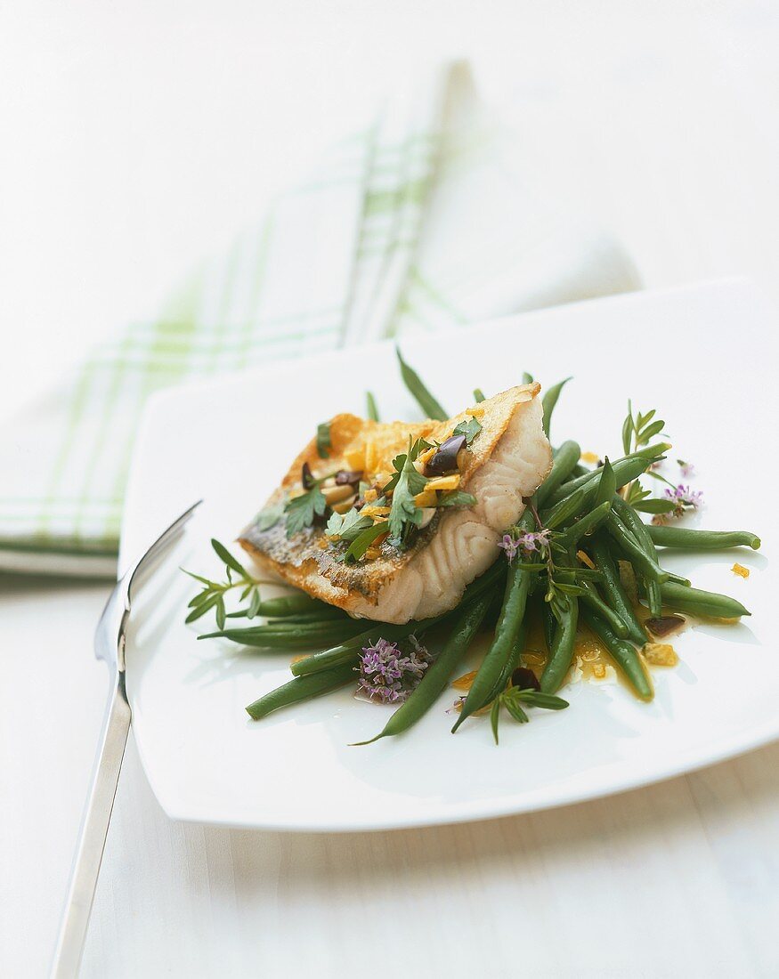 Fried zander with olives and parsley on green beans