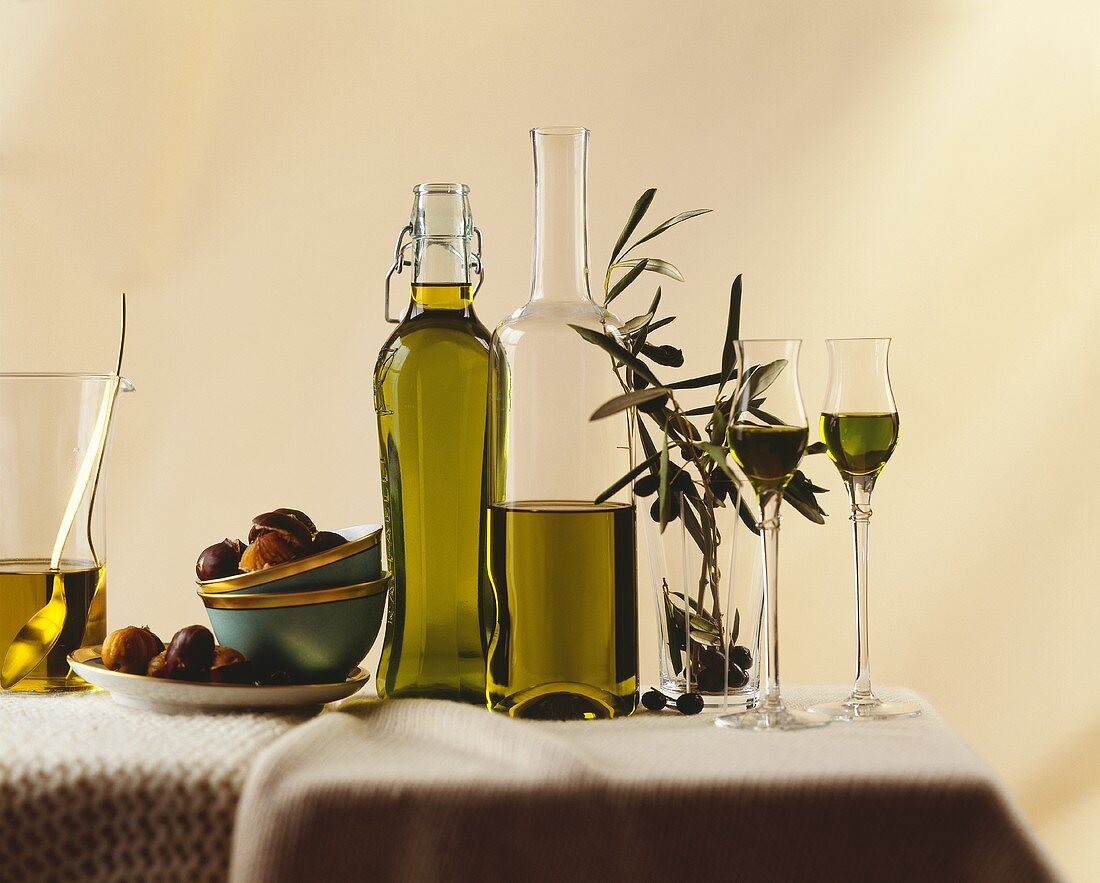 Olivenöl in Flaschen, Gläsern, mit Olivenzweig, Esskastanien