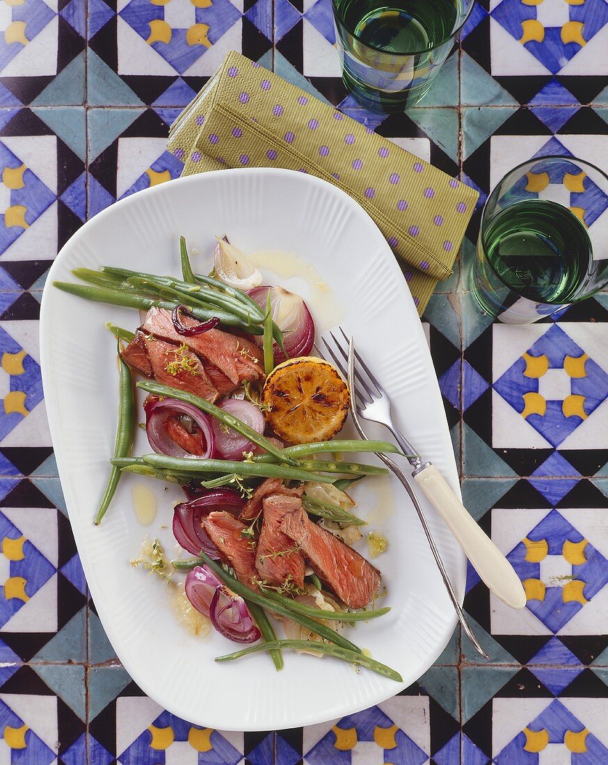 Strips of entrecôte steak with bean and onion salad