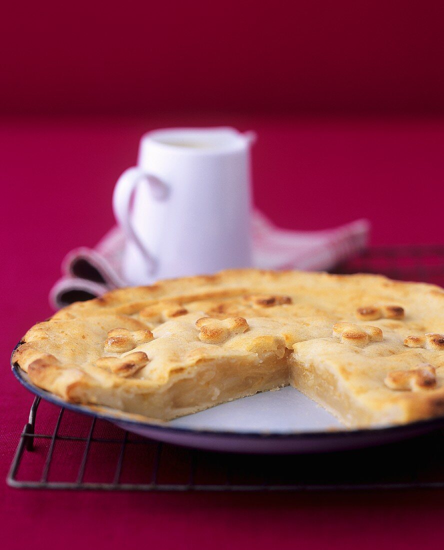 Apple and potato pie with a small jug of custard