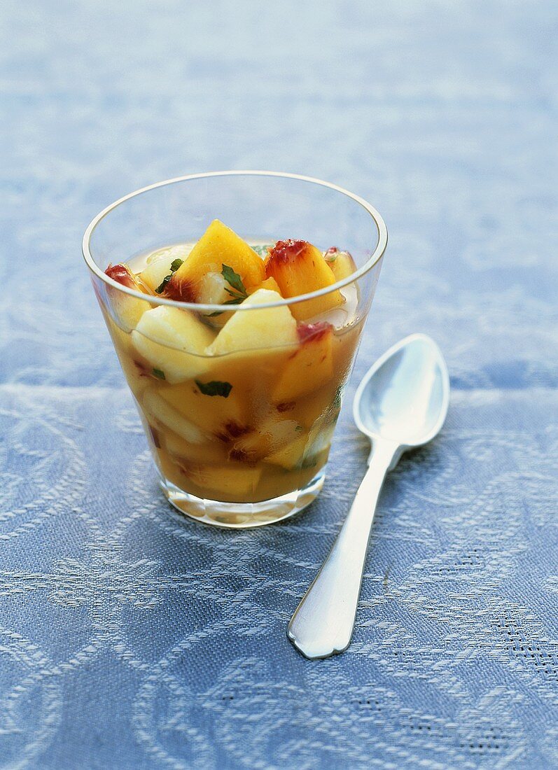 Peach salad with amaretto in a glass