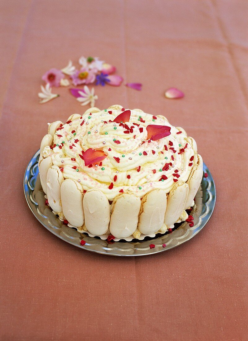 Vacherin-Torte mit Eis, Schlagsahne, Zuckerperlen und Blüten
