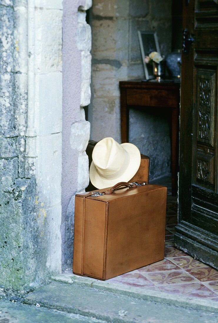 Suitcaise and hat in a house doorway