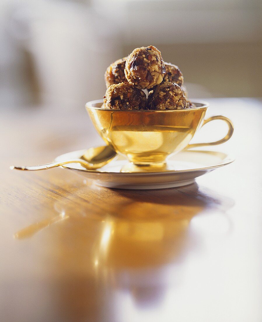 Amaranth and dried fruit truffles in a cup and saucer