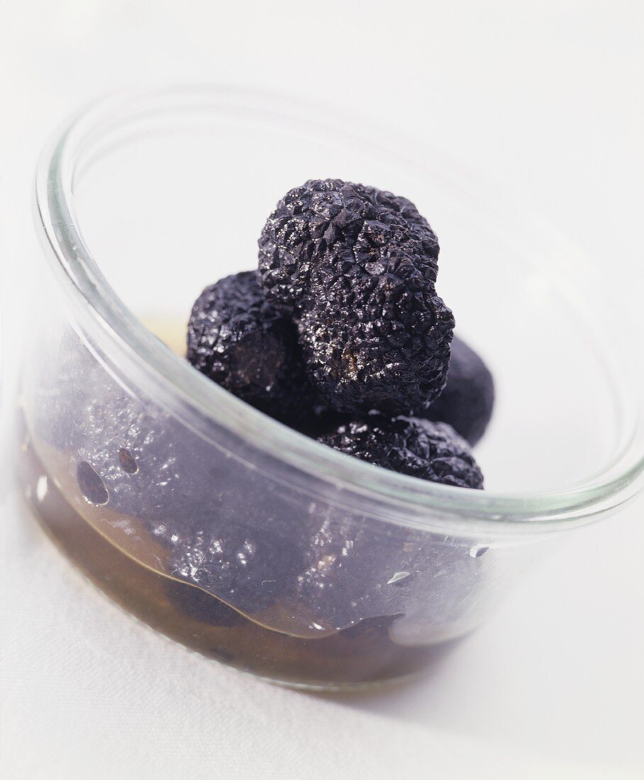 Pickled black truffles in a glass bowl