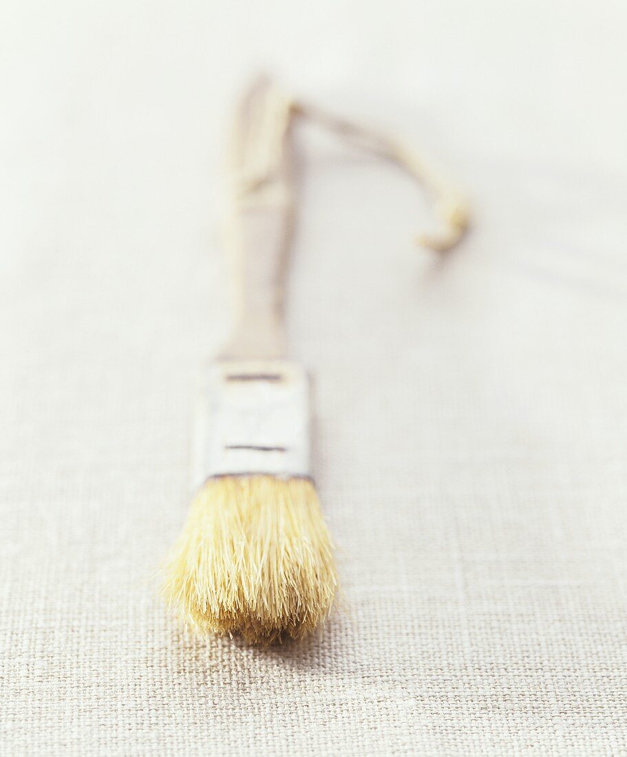A wooden pastry brush on a linen cloth