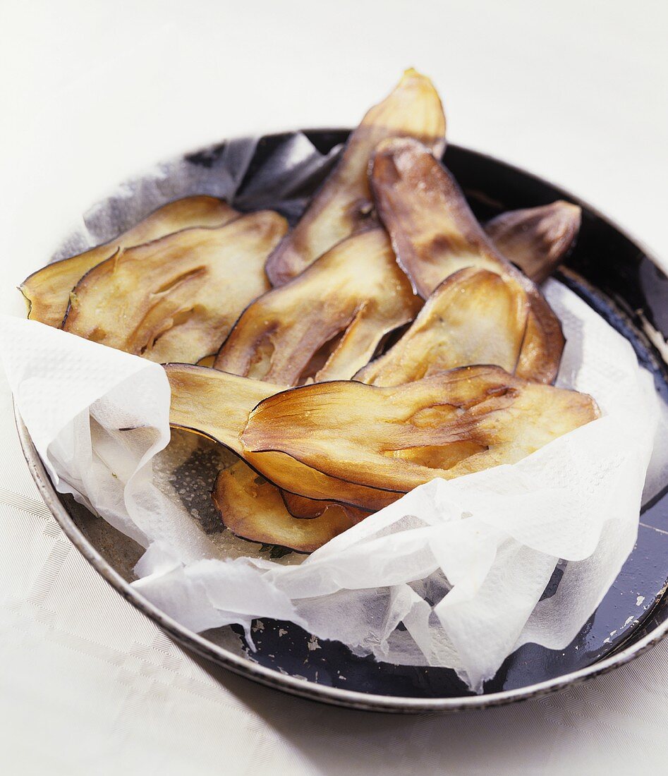 Auberginen-Chips tropfen auf Küchenkrepp ab
