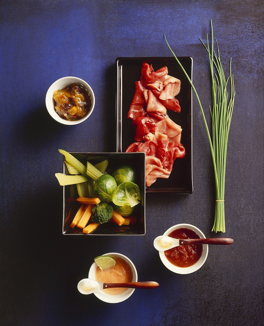 Meat, vegetables and dips for shabu-shabu