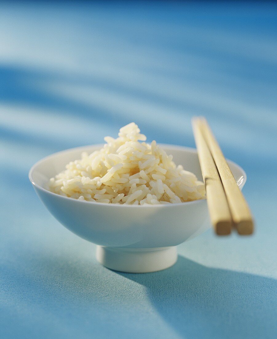 A bowl of fried rice with chopsticks