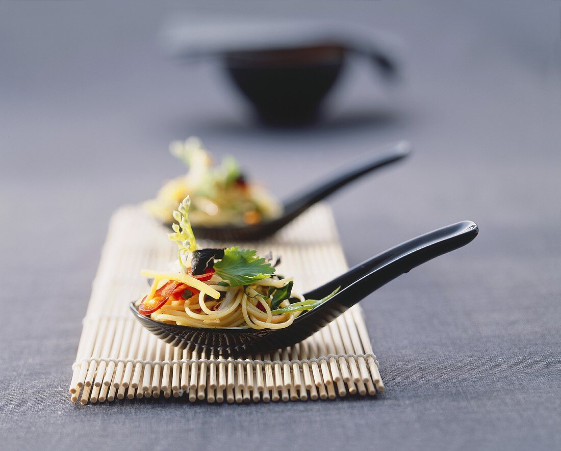 Asian noodle and vegetable salad on spoons