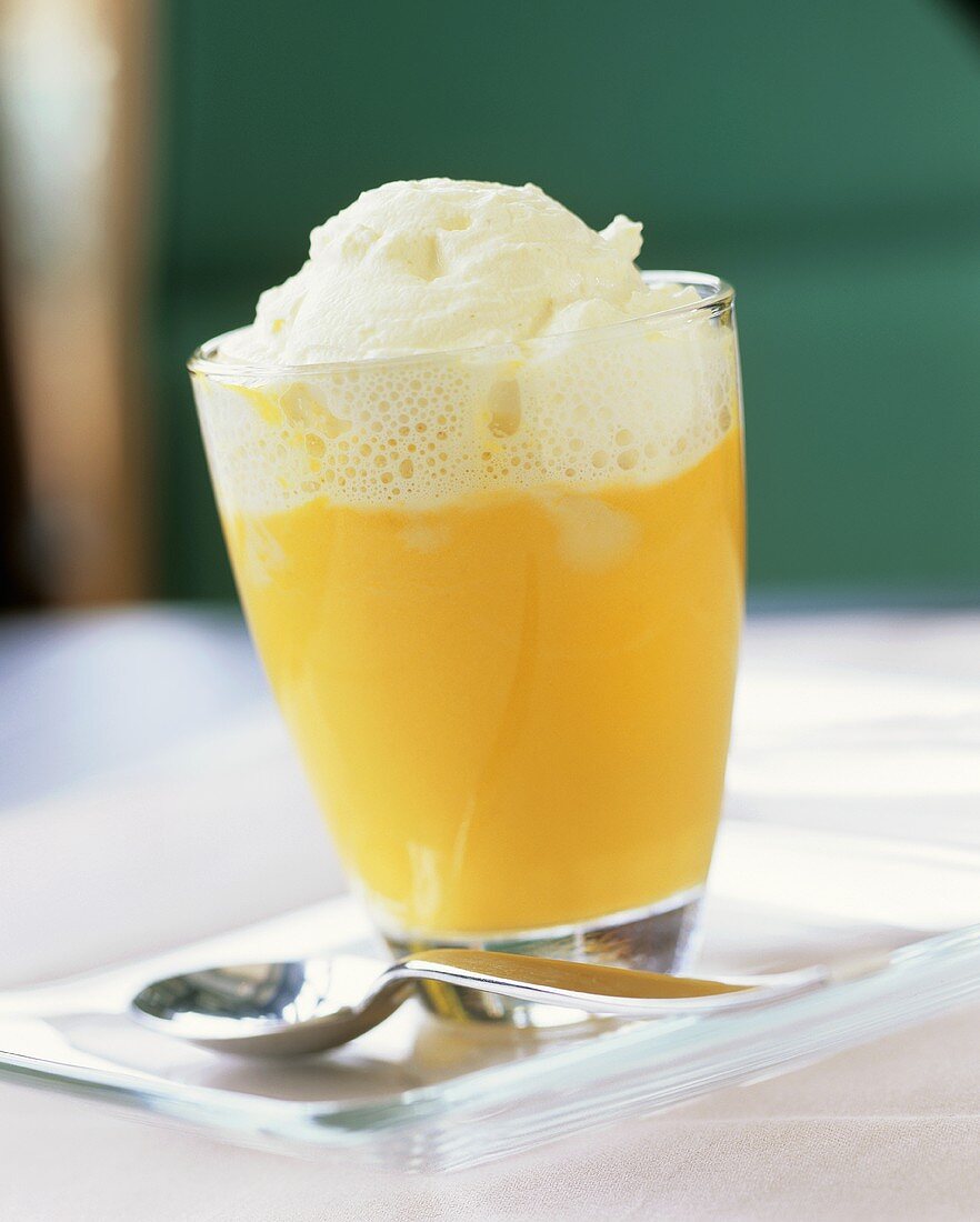 Pumpkin and orange soup with whipped cream in a glass