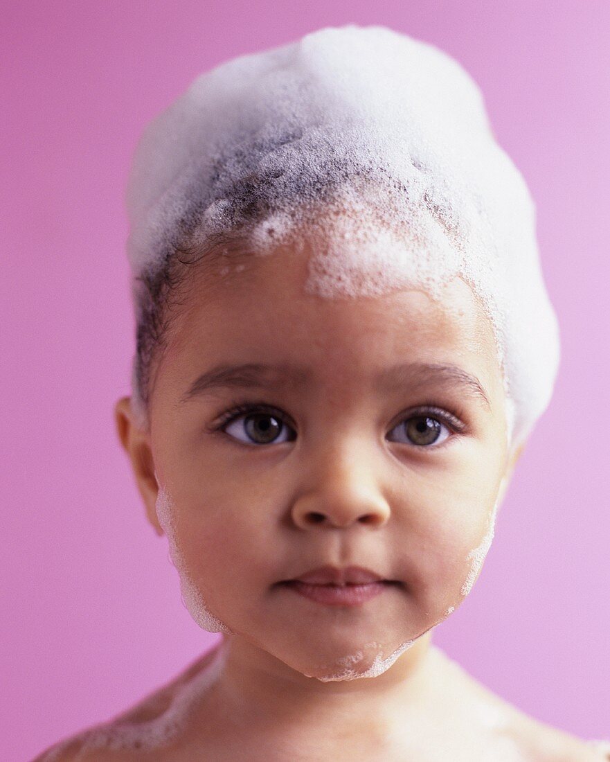 Little girl with her hair covered in shampoo