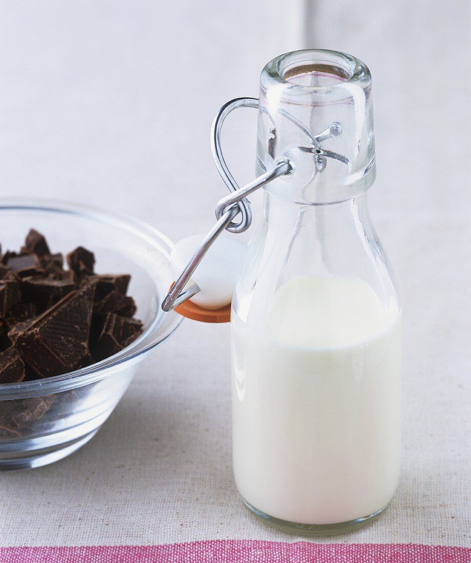 Eine Flasche Sahne und gehackte Schokolade für Ganache