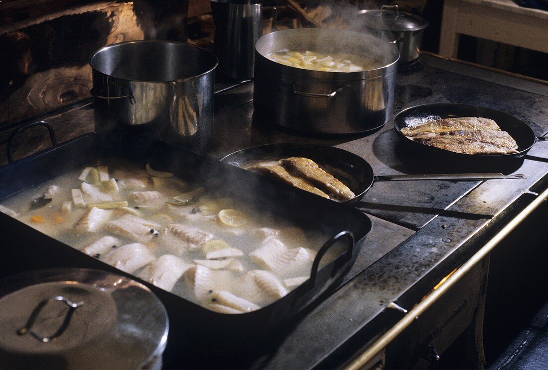 Verschiedene Fischgerichte auf einem alten Holzofen