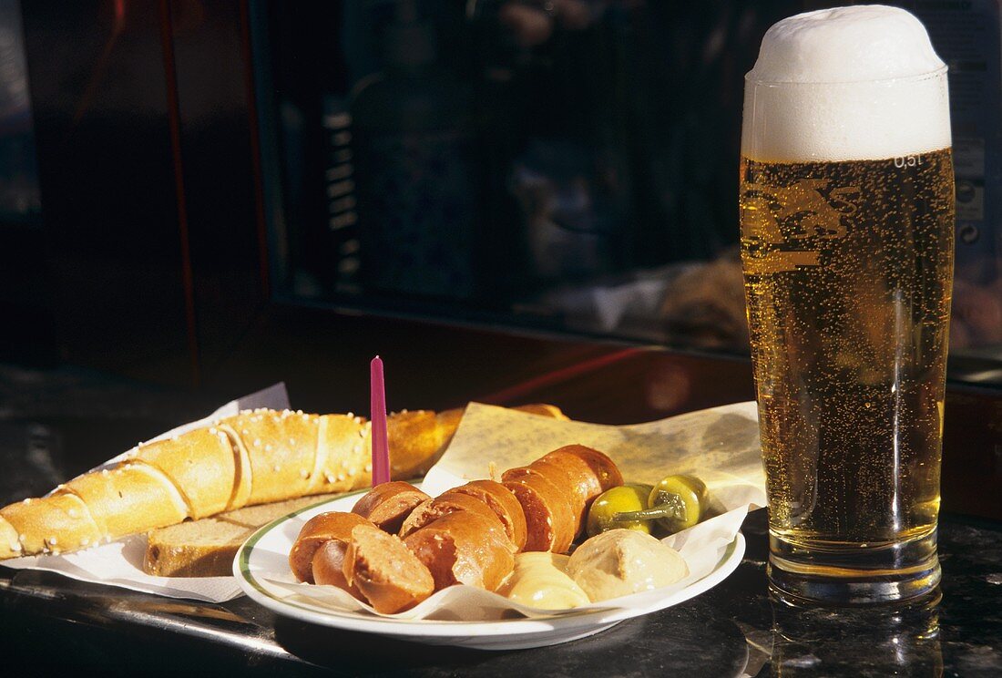 Käsewurst mit einem Glas Bier am Imbissstand