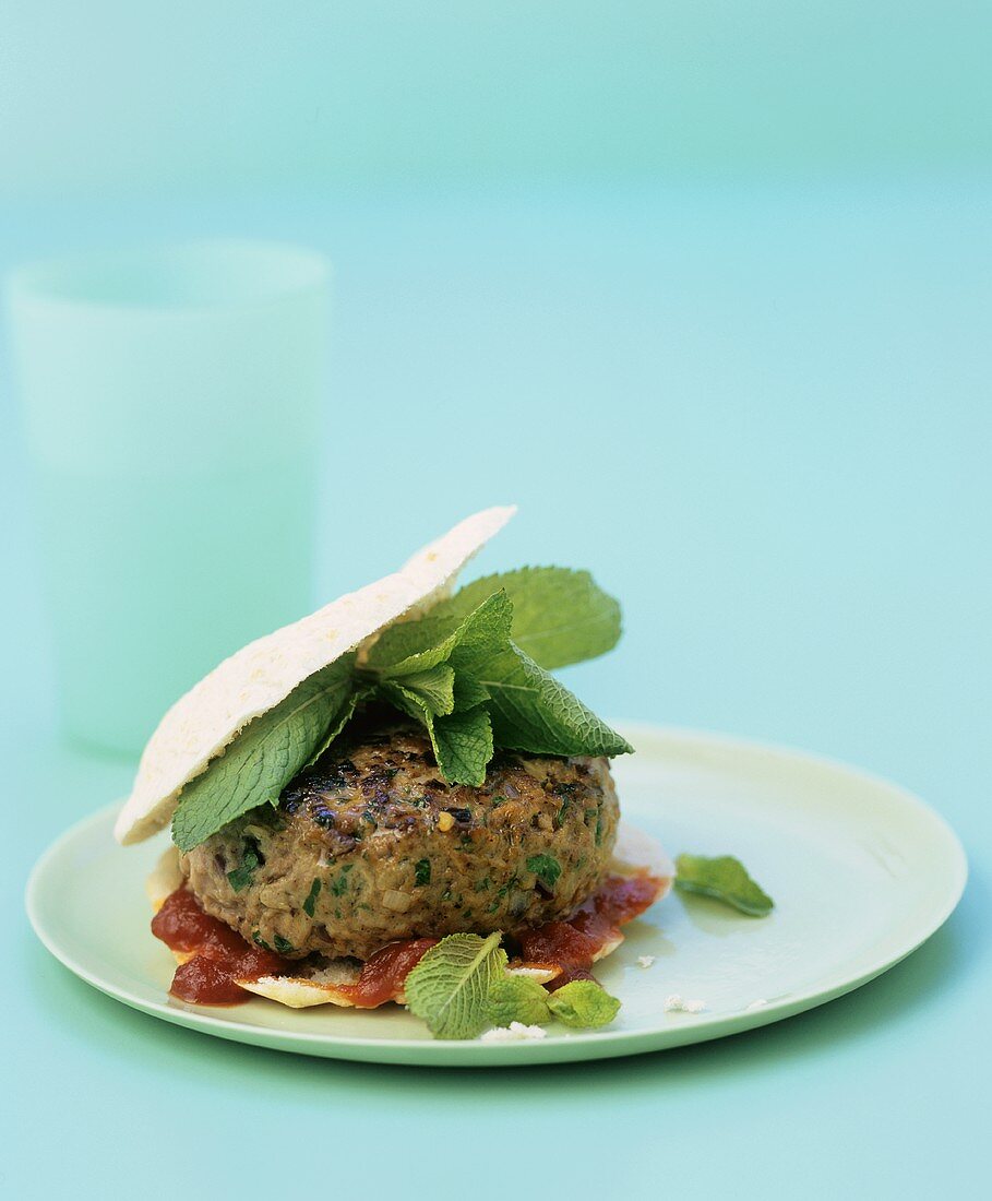 Lamb burger with mint and tomato sauce in pita bread