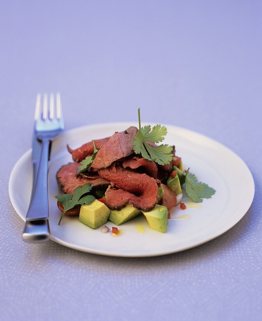 Sliced adobo beef fillet with guacamole