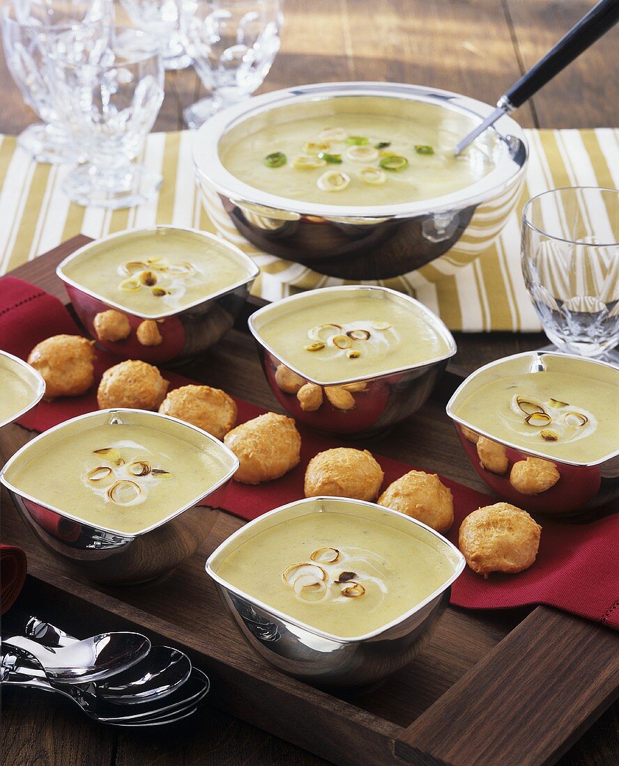 Cream of vegetable soup in tureen and bowls, pastries
