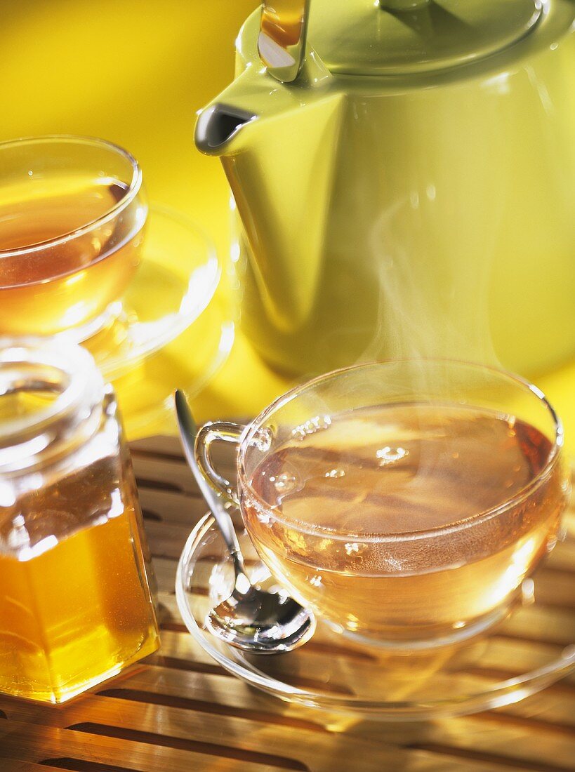 Cups of tea, teapot and honey