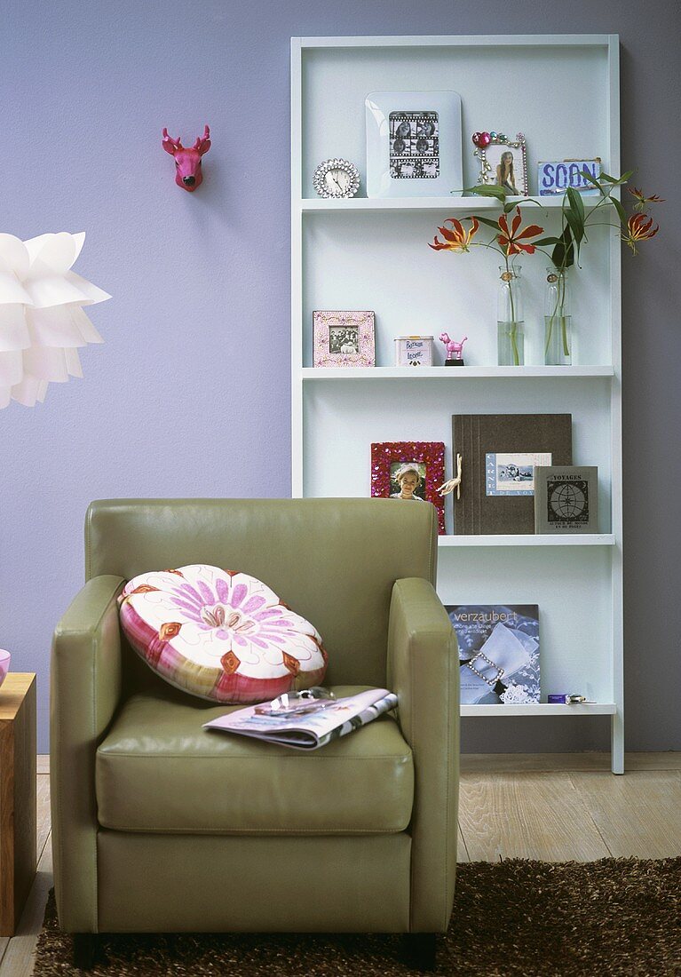 Sitting room with leather armchair and display unit with pictures