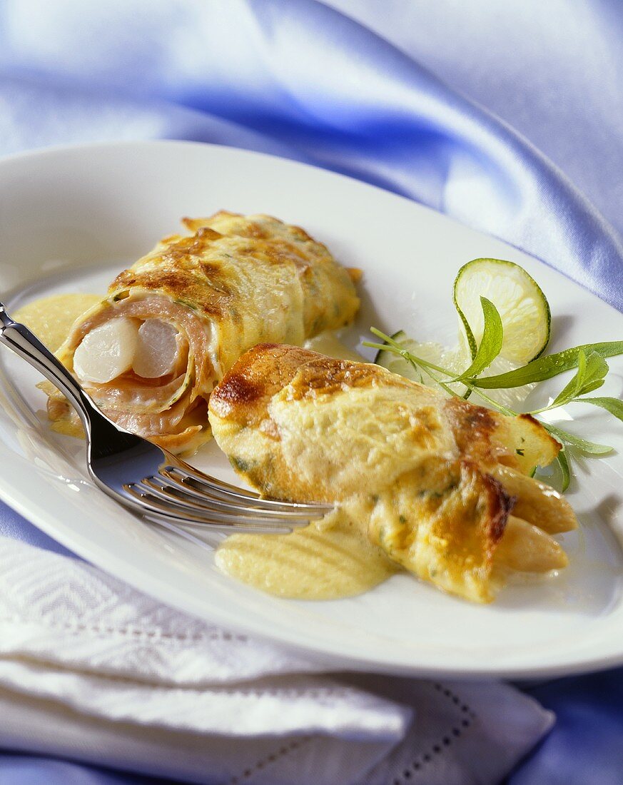 Pancake and smoked salmon rolls filled with asparagus, melted cheese