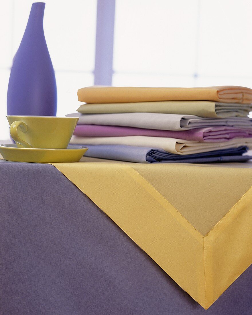 Tisch mit pastellfarbenem Geschirr und Tüchern
