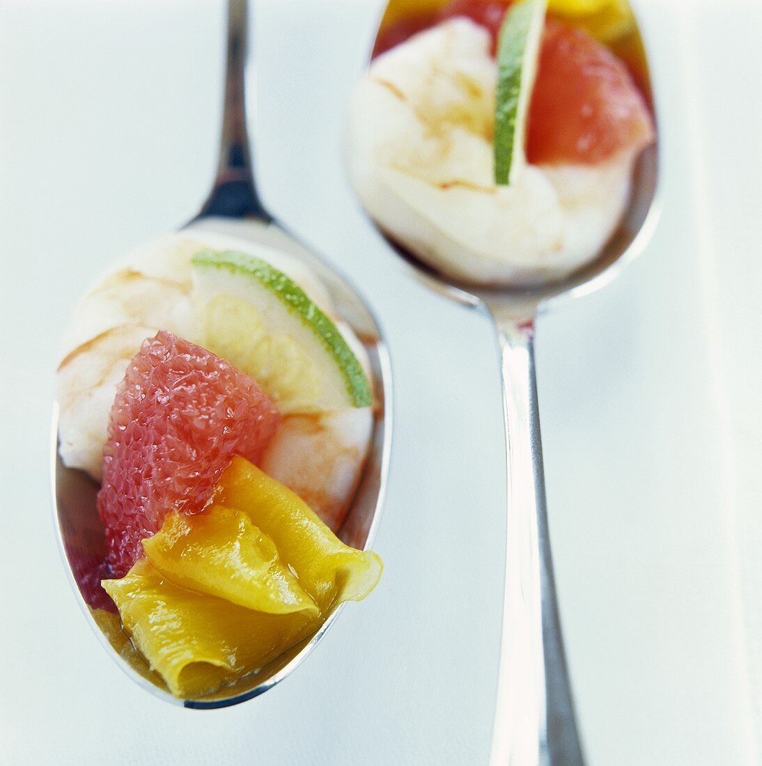 Prawns with lime, grapefruit and mango on two spoons