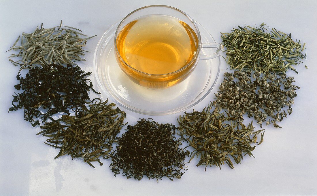 Verschiedene Sorten grüner Tee mit einer Teetasse