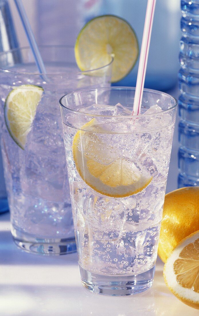 Zwei Gläser Mineralwasser mit Eis, Zitronen-, Limonenscheiben
