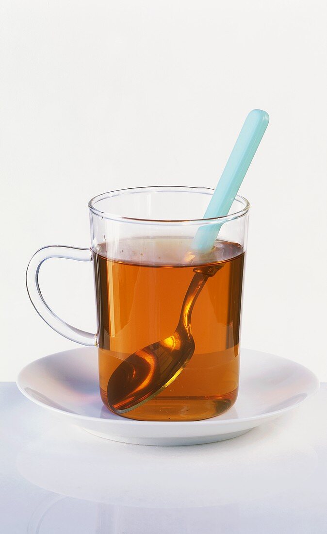 A glass of black tea with spoon