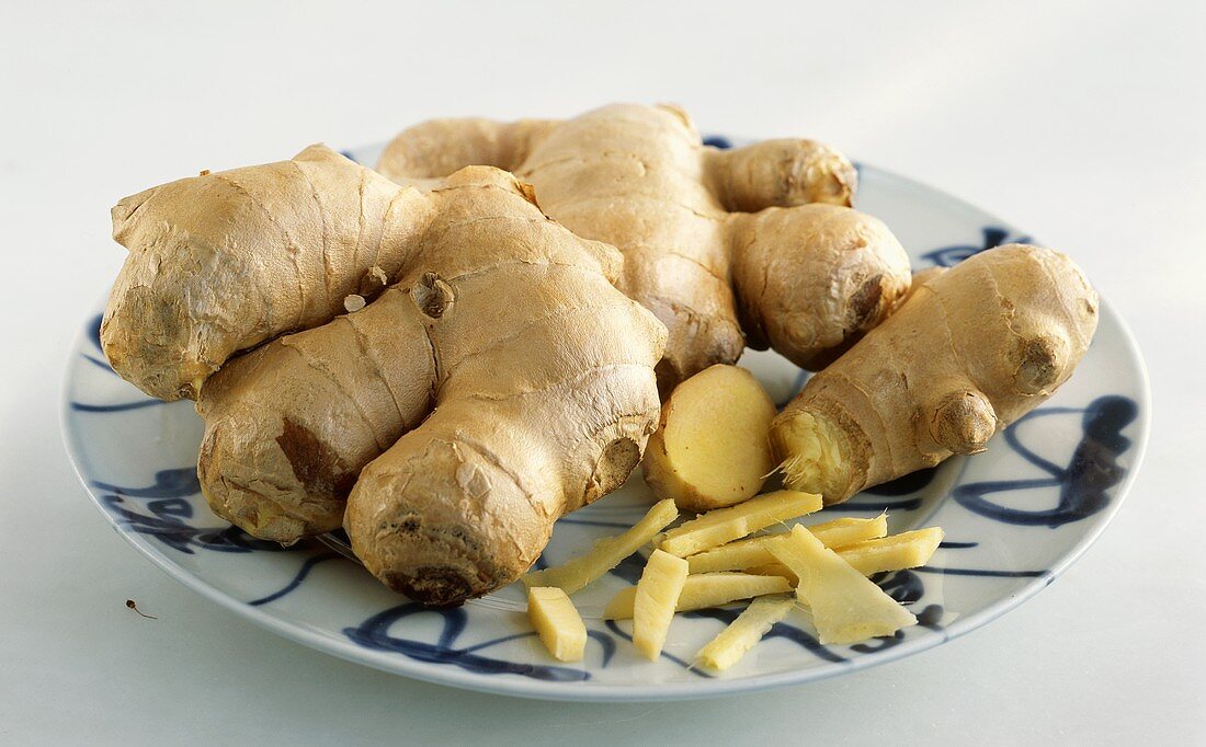 Fresh ginger on a plate, whole and pieces