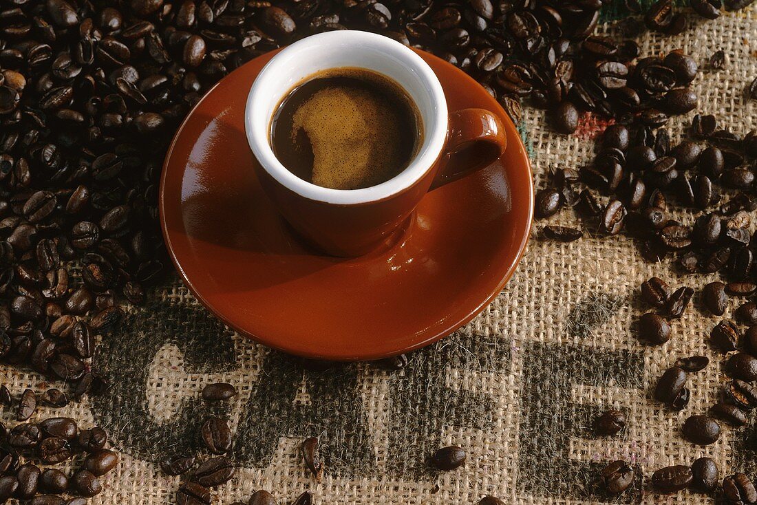 Tasse Espresso, Kaffeebohnen auf Jutesack: Aufschrift 'Café'
