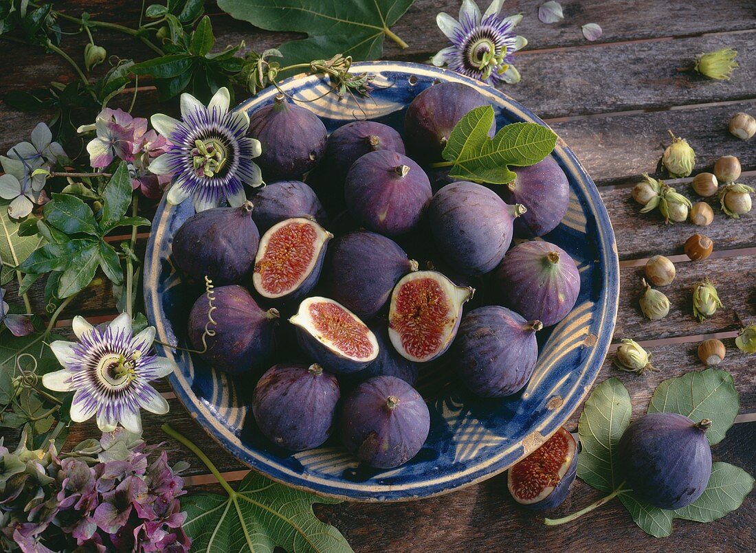 Bowl of figs, hazelnuts, flowers