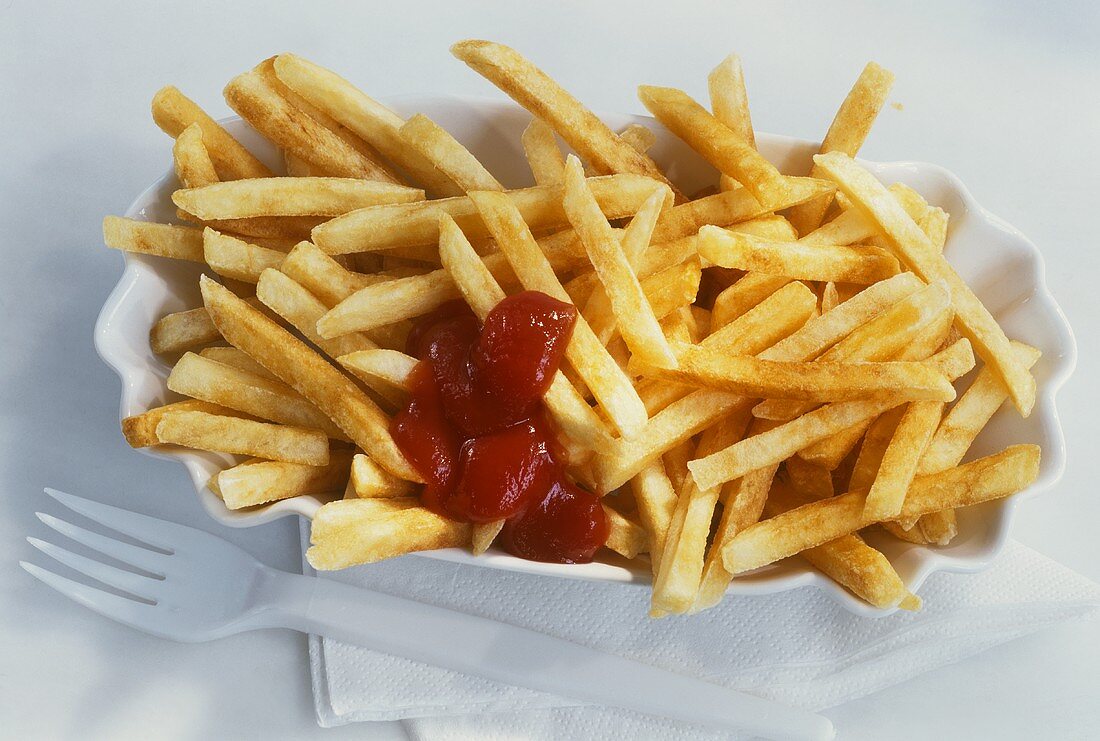 Dish of chips with ketchup, paper napkin and plastic fork