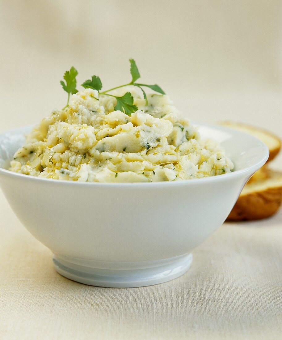 A bowl of mashed potato with coriander and olive oil